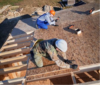 Roofers laying a new covering on a pitched roof