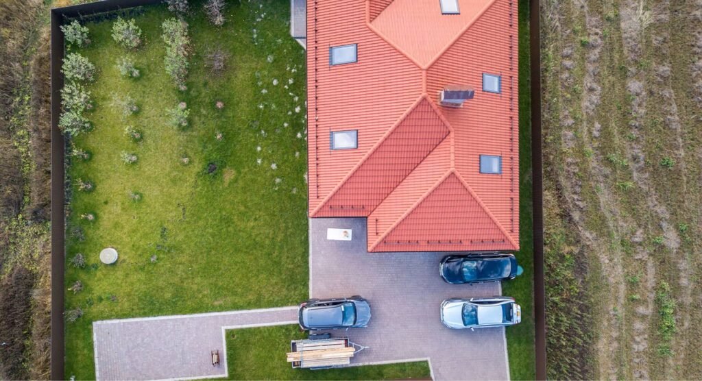 Aerial drone view of a house roof with red tiles during a roof inspection