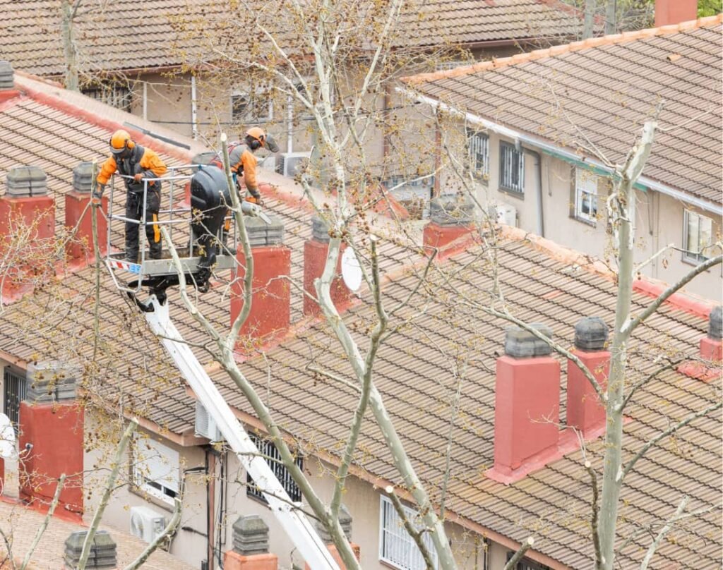 Roofers using a cherry picker to repair terraced house roofs in Bristol